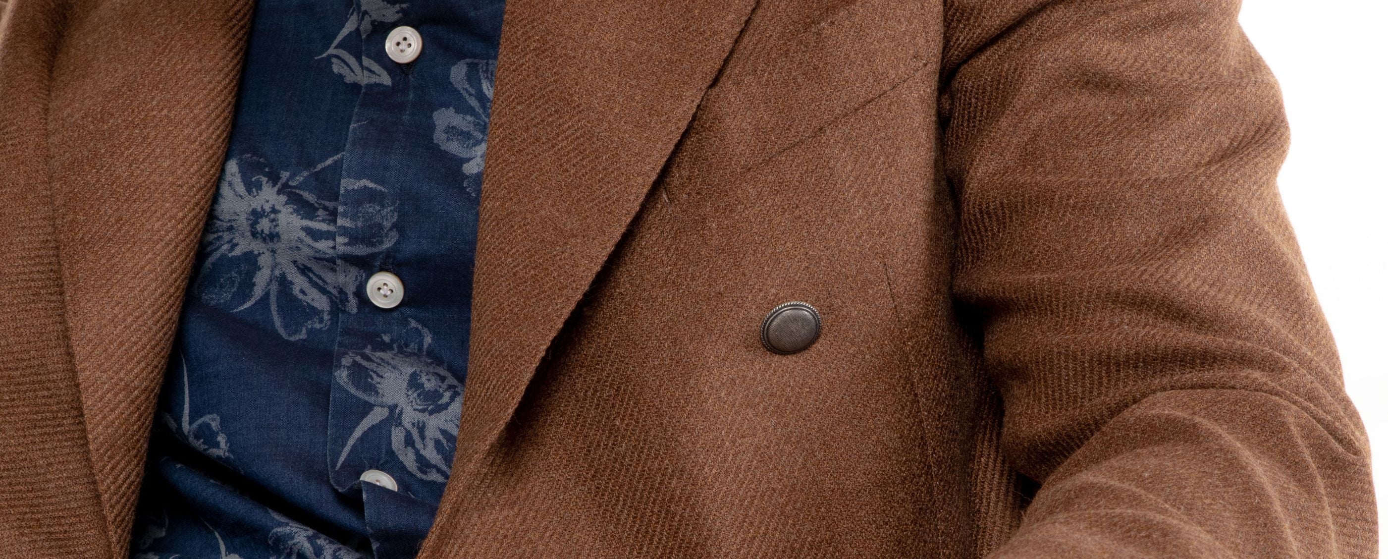 Brown textured blazer with a single button, worn over a navy floral shirt.